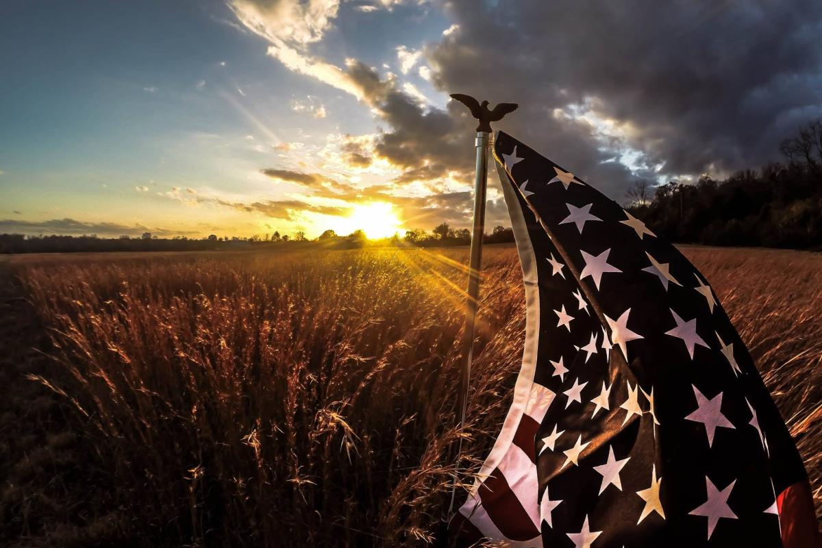 American flag flying over fields in white co Ark
